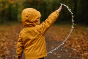 Svart barnjacka med vita och rosa detaljer på väderbeständig modell.